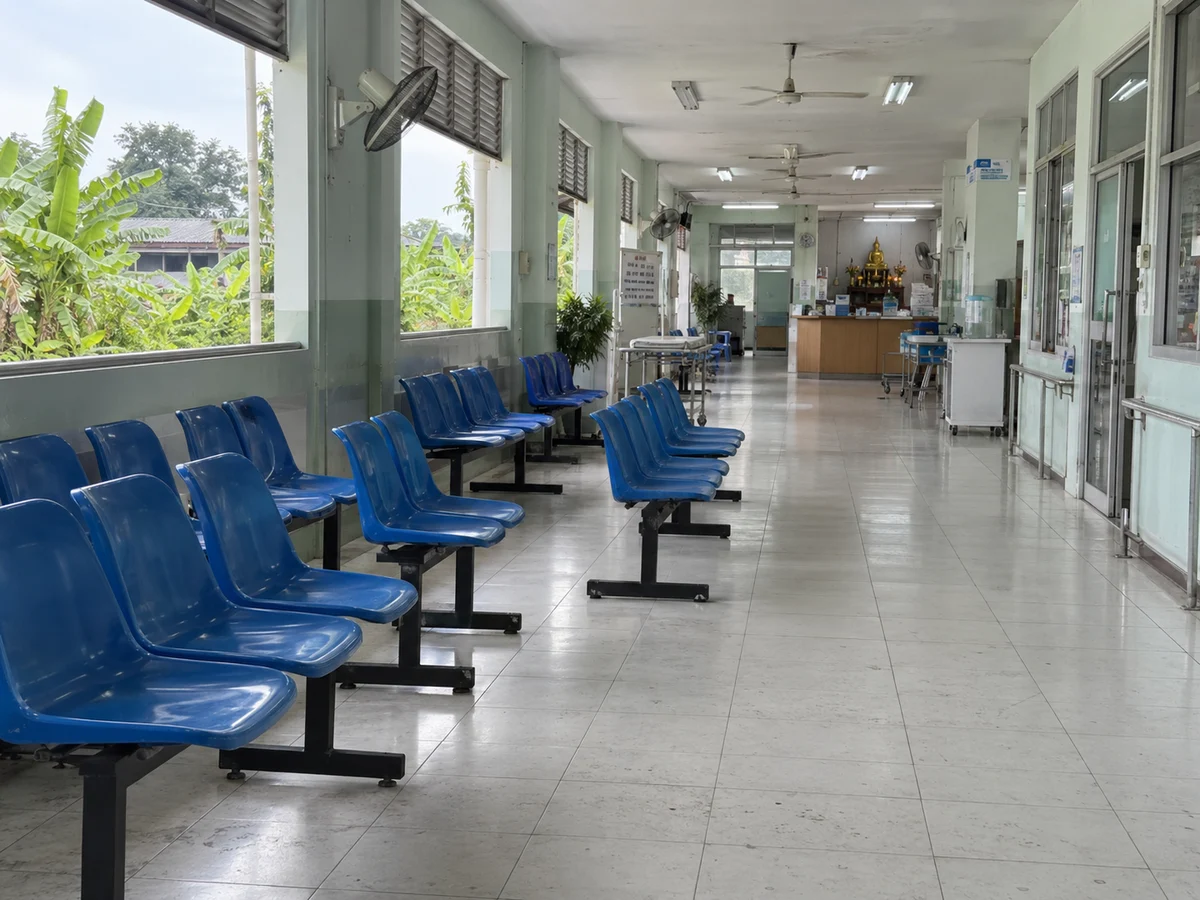 Empty hospital waiting corridor with blue seats (AI-generated illustration)